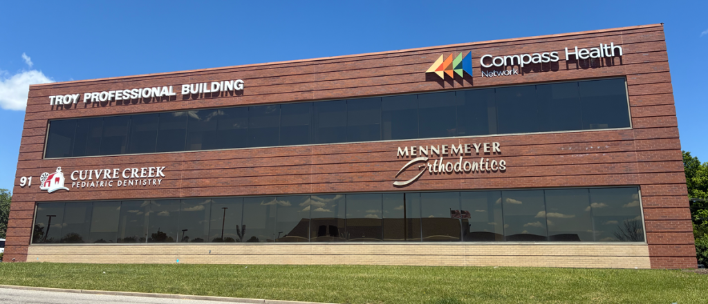 Brick office building with multiple signs: Troy Professional Building, Compass Health Network, Cuivre Creek Pediatric Dentistry, and Mennemeyer Orthodontics.